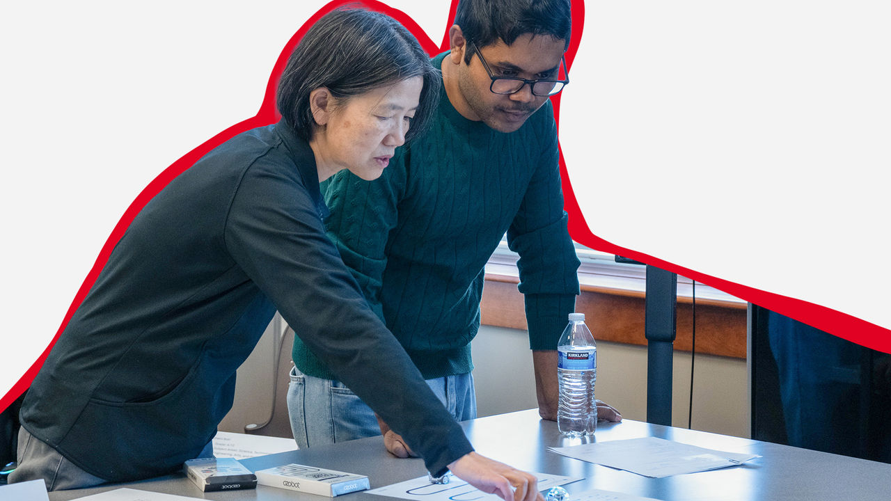 Professor and student in classroom working on project
