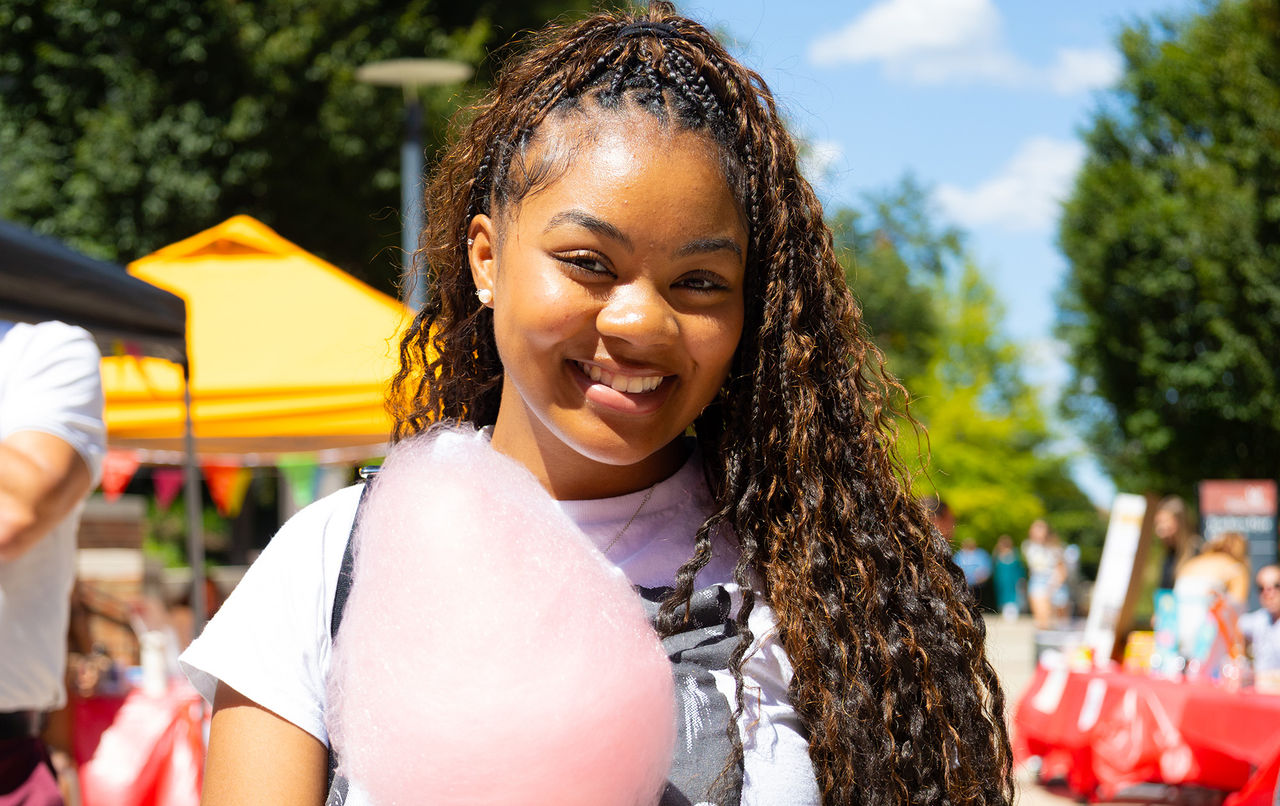 African American girl holding cotton candy at CECH Carnival