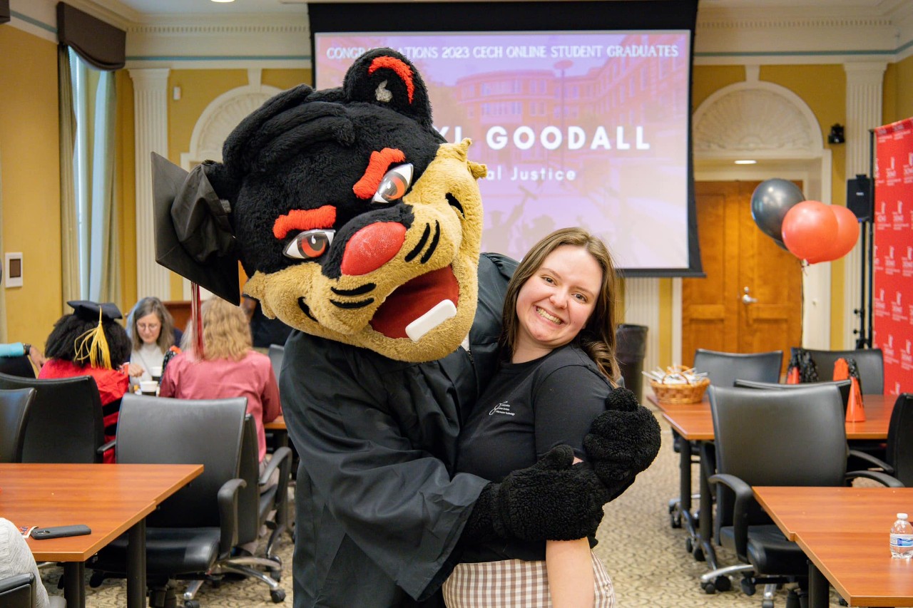 Bearcat hugging a student services center member